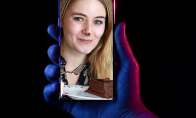 photo of lady on phone eating cake