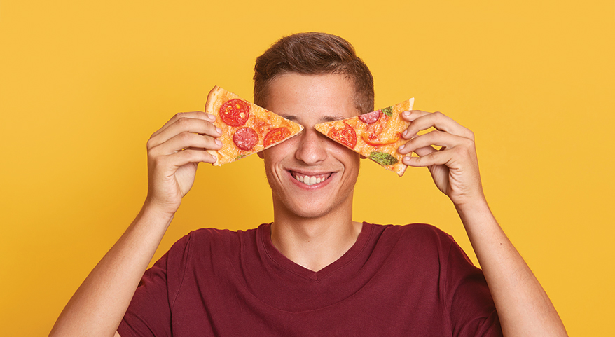 guy holds pizza on eyes