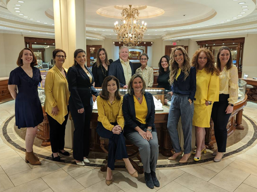 Even though this virtual silent auction has concluded, the staff of Roman Jewelers continues to raise awareness by inspiring others. Co-owner, Lucy Zimmerman (seated, left), is set to design a new pendant to continue fundraising efforts.